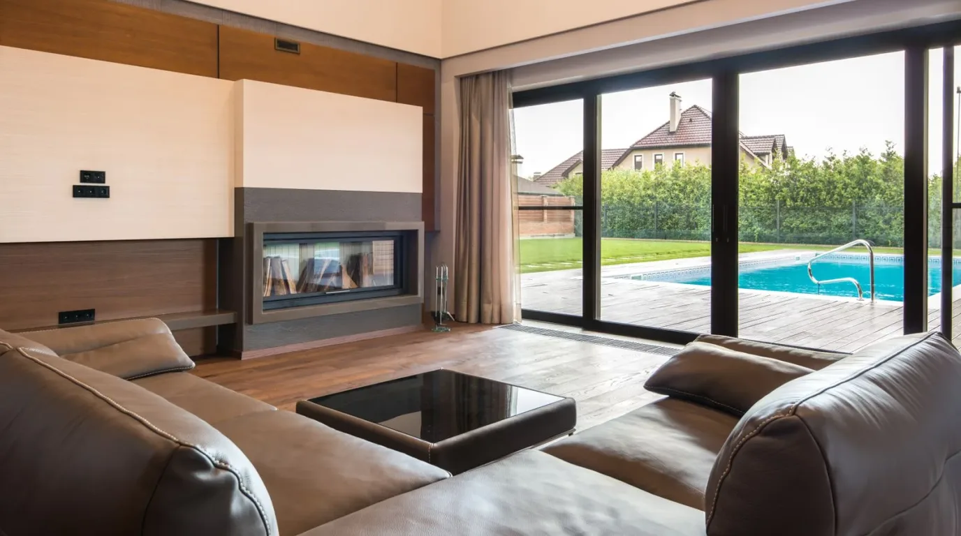 Living room with floor-to-ceiling sliding glass doors opening to a pool