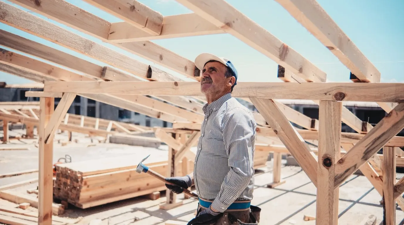 Construction worker framing a roof under a clear blue Florida sky